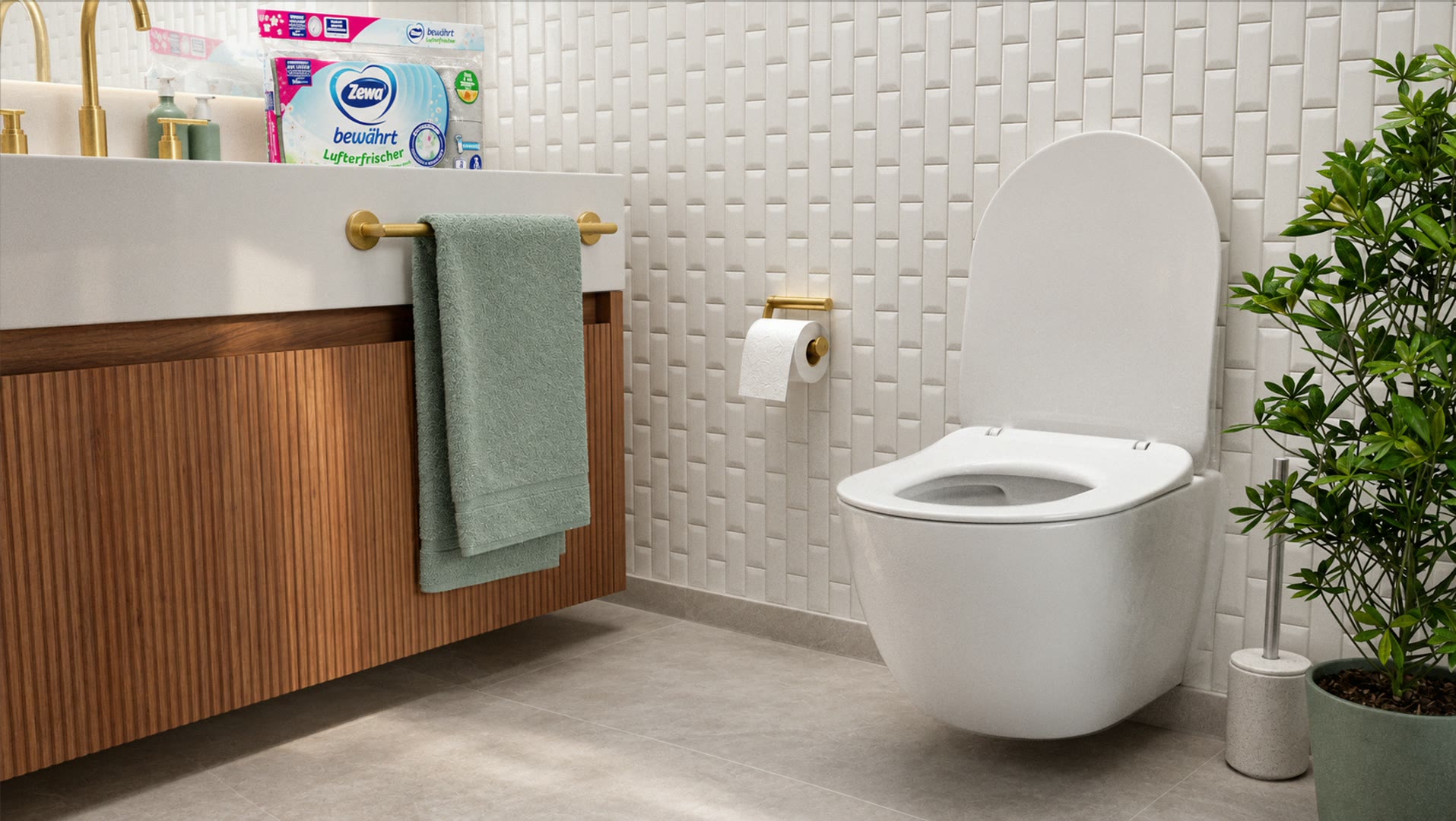 Een badkamer met een rol toiletpapier aan een gouden houder en een pak Zewa op de wastafel.