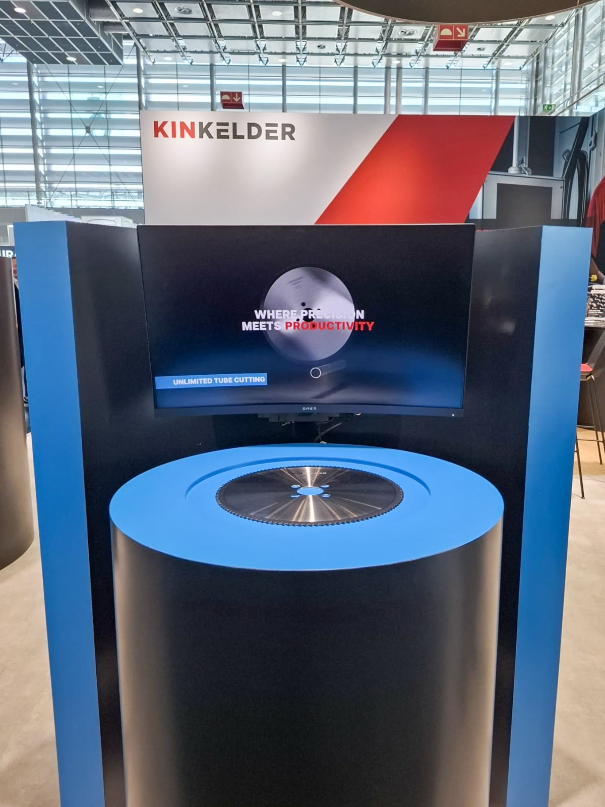 Een blauwe zuil met een zaagblad en een scherm op de beursstand.