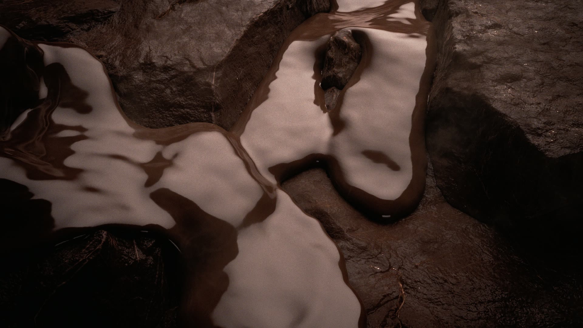 Melk en chocolade vloeien samen over rotsen.