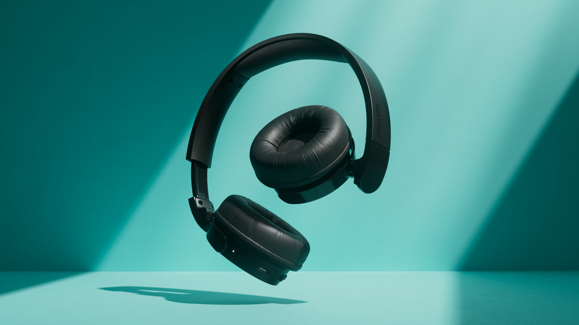 De koptelefoon zwevend in turquoise.